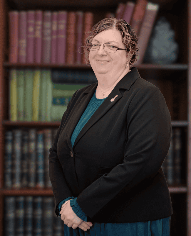 Andrea Murchland — French Burt Partners Lawyers, New Zealand standing in front of a book case