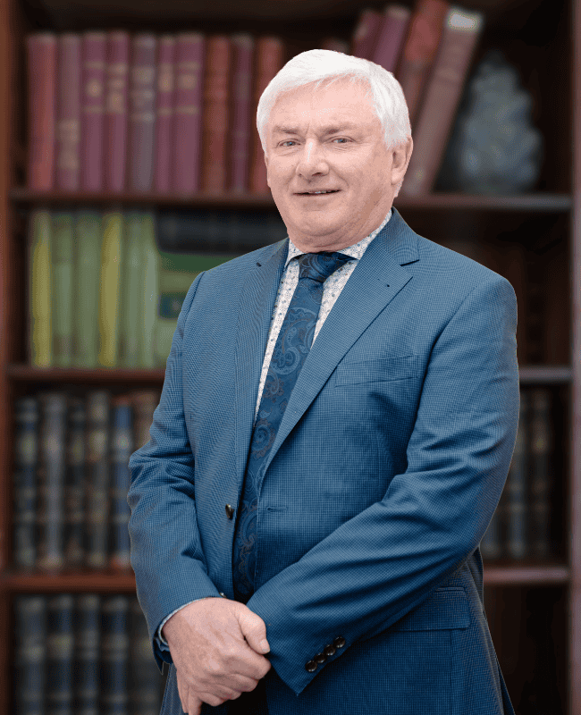 Craig Smith — French Burt Partners Lawyers, New Zealand standing in front of a book case