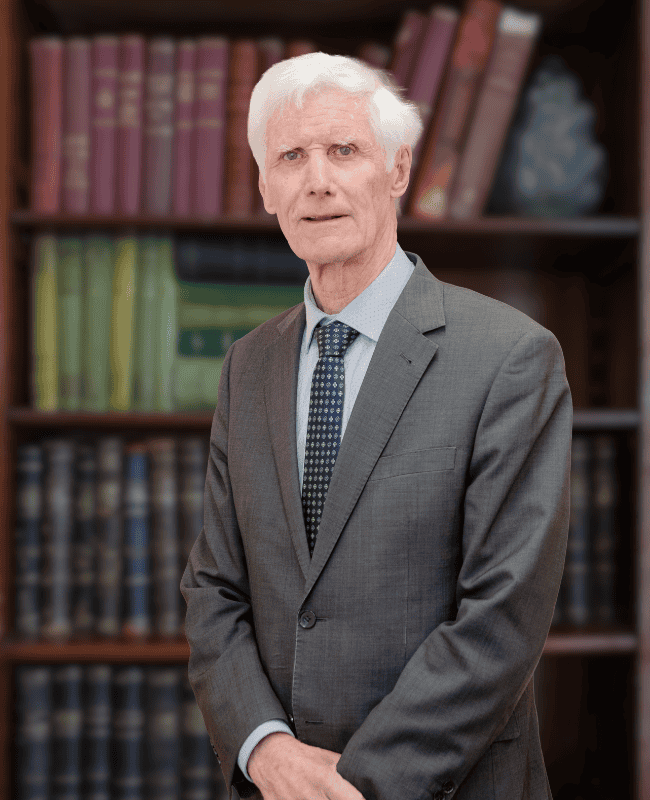John French — French Burt Partners Lawyers, New Zealand standing in front of a book case